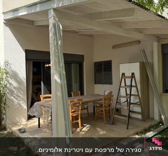 פרגולה מאלומיניום בחצר עם שולחן וכיסאות